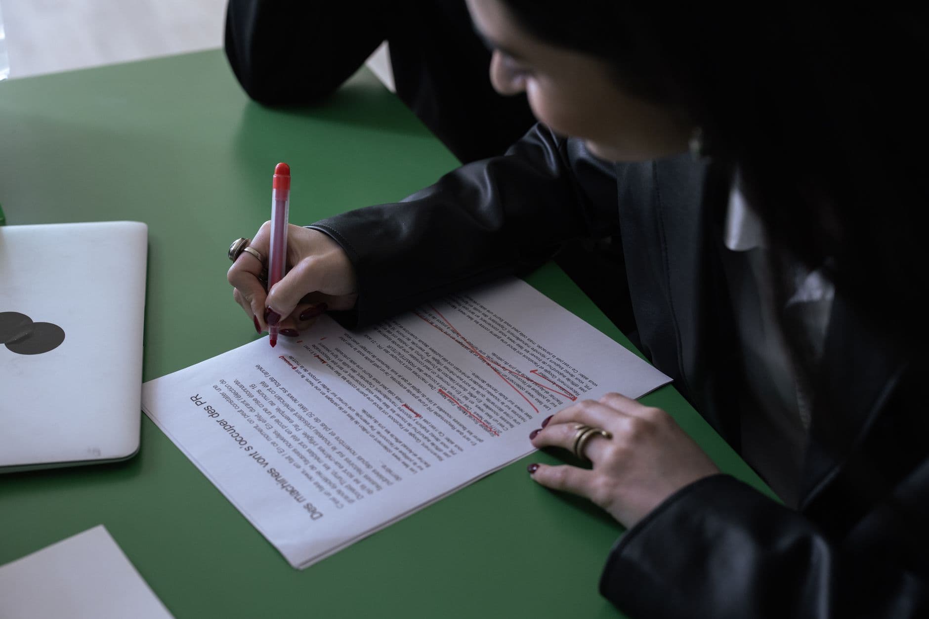 An editor marking up a printed draft with a pen